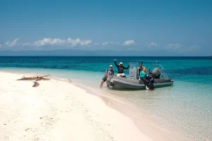 inflatable boat beach group people clear water tropical island